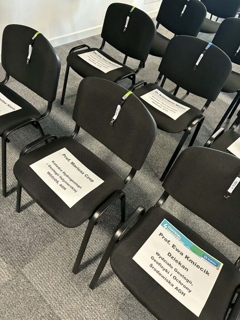 puste krzesła z kartkami podpisanymi imionami prelegentow