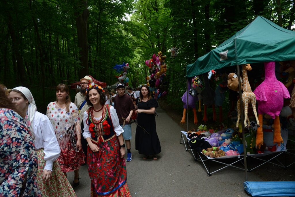 odpust na bielanach 2026, aleja wedrownikow, stoja kramy, ida ludzie, w tym panie w strojach krakowskich