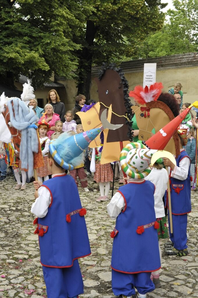 grupa dzieci w kolorowych czapkach i strojach ludowych